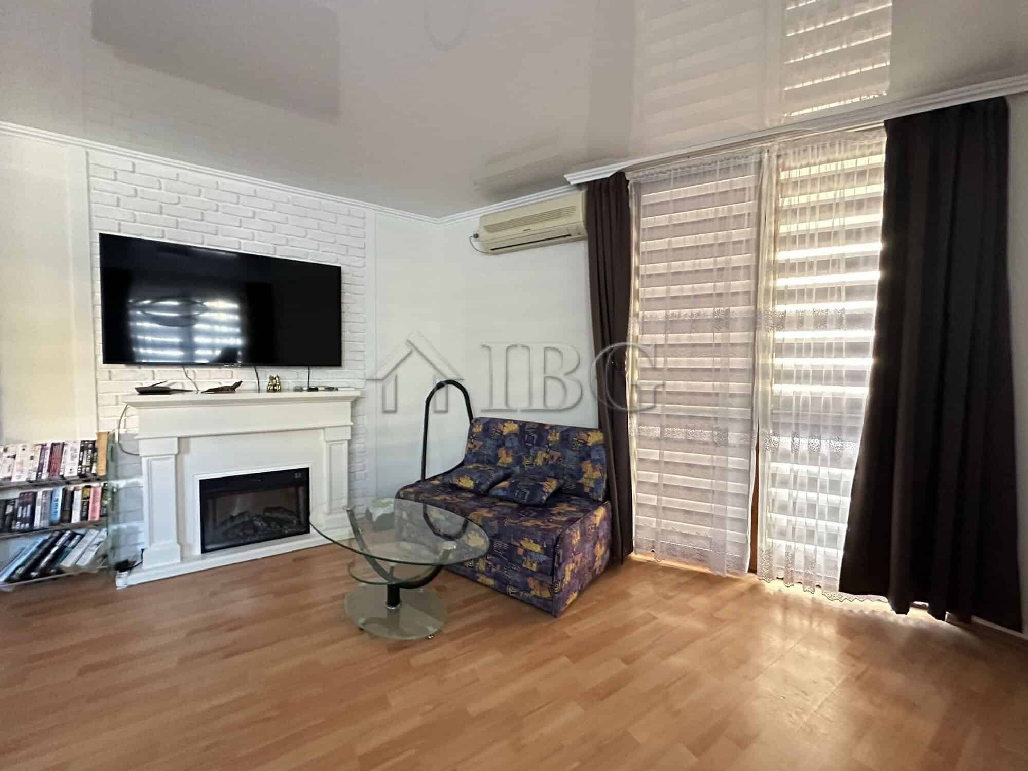 Bright living room with TV, sofa, and large windows in Sveti Vlas apartment.
