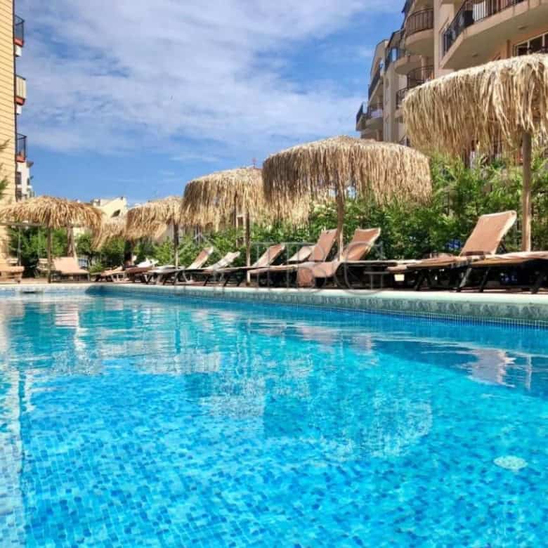 Pool area with sun loungers and thatched umbrellas at Sunny View Central, Sunny Beach.