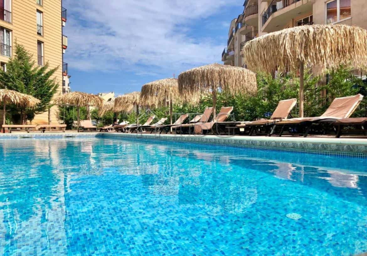 Pool area with sun loungers and thatched umbrellas at Sunny View Central, Sunny Beach.