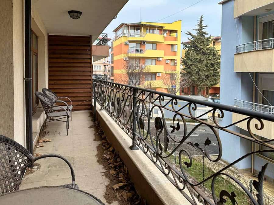 Balcony with sea view in Ravda, Bulgaria, featuring outdoor seating and urban surroundings.