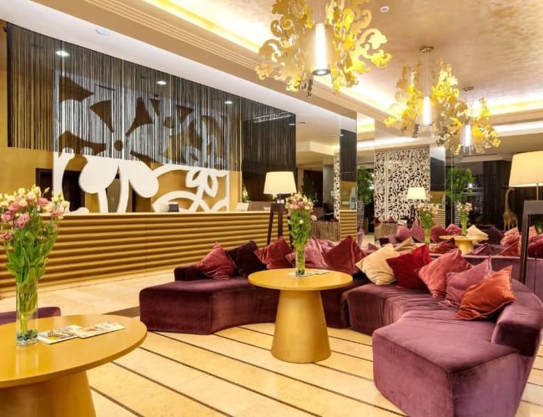 Elegant hotel lobby with plush seating, floral arrangements, and warm lighting in Sunny Beach.