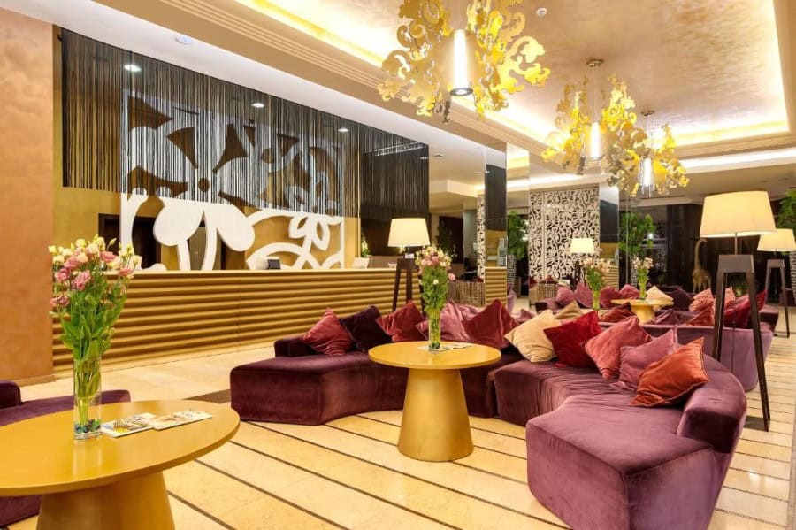 Elegant hotel lobby with plush seating, floral arrangements, and warm lighting in Sunny Beach.
