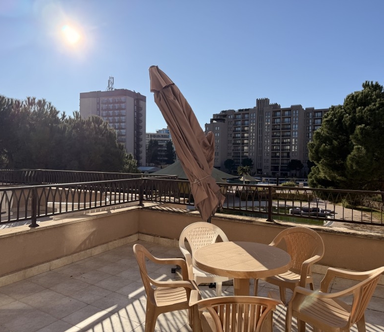 Balcony with outdoor seating and large terrace overlooking Sunny Beach skyline.