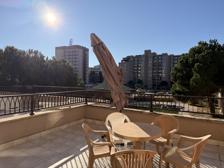 Balcony with outdoor seating and large terrace overlooking Sunny Beach skyline.