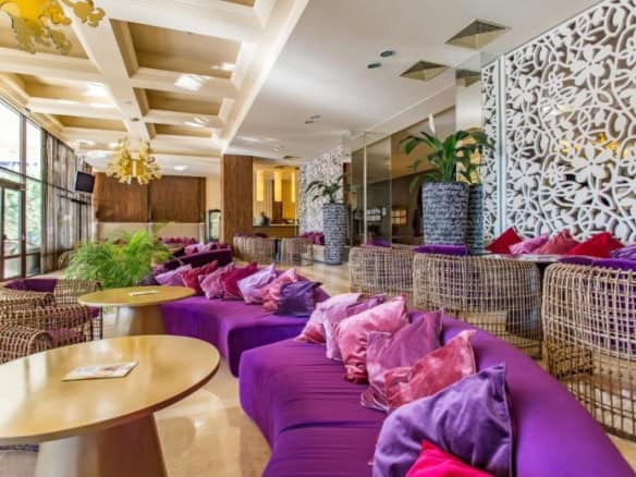Modern lounge with vibrant purple seating and large terrace views.