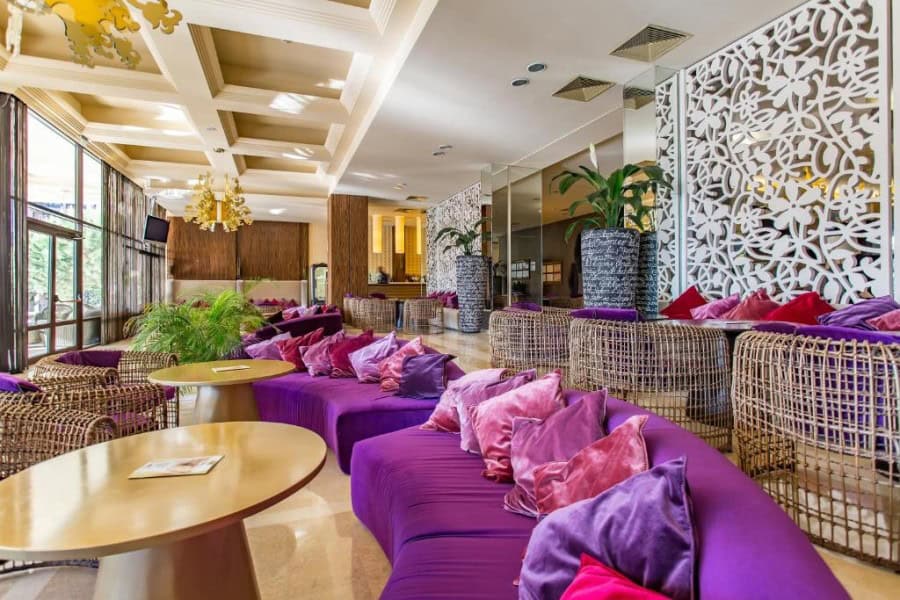 Modern lounge with vibrant purple seating and large terrace views.