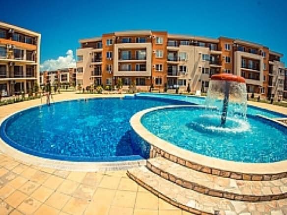 Spacious outdoor pool area at Holiday Fort Club in Sunny Beach with sun loungers and fountain featur.