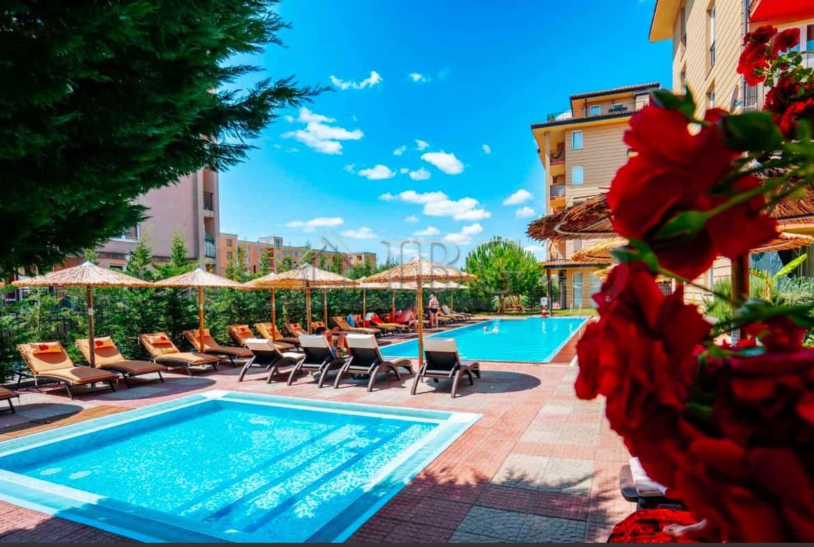 Pool area at Sunny View Central, Sunny Beach with sun loungers and umbrellas for relaxation.