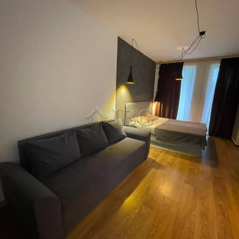 Modern studio apartment with balcony, living area, and bed in Sunny View Central, Sunny Beach.