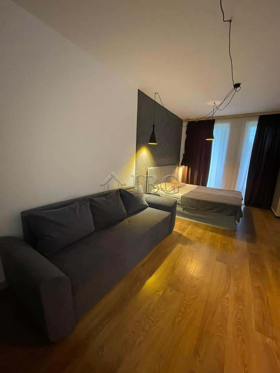 Modern studio apartment with balcony, living area, and bed in Sunny View Central, Sunny Beach.