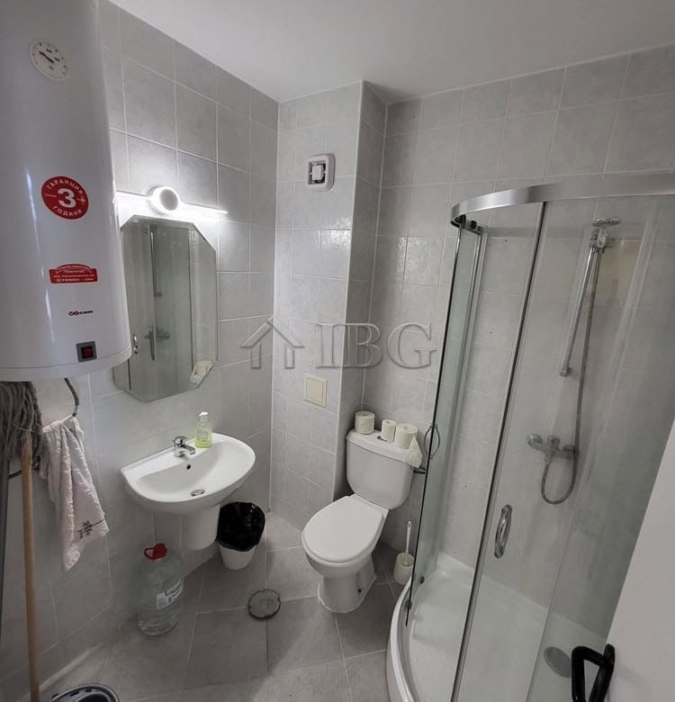 Compact bathroom with shower, toilet, and sink in Sunset Kosharitsa.