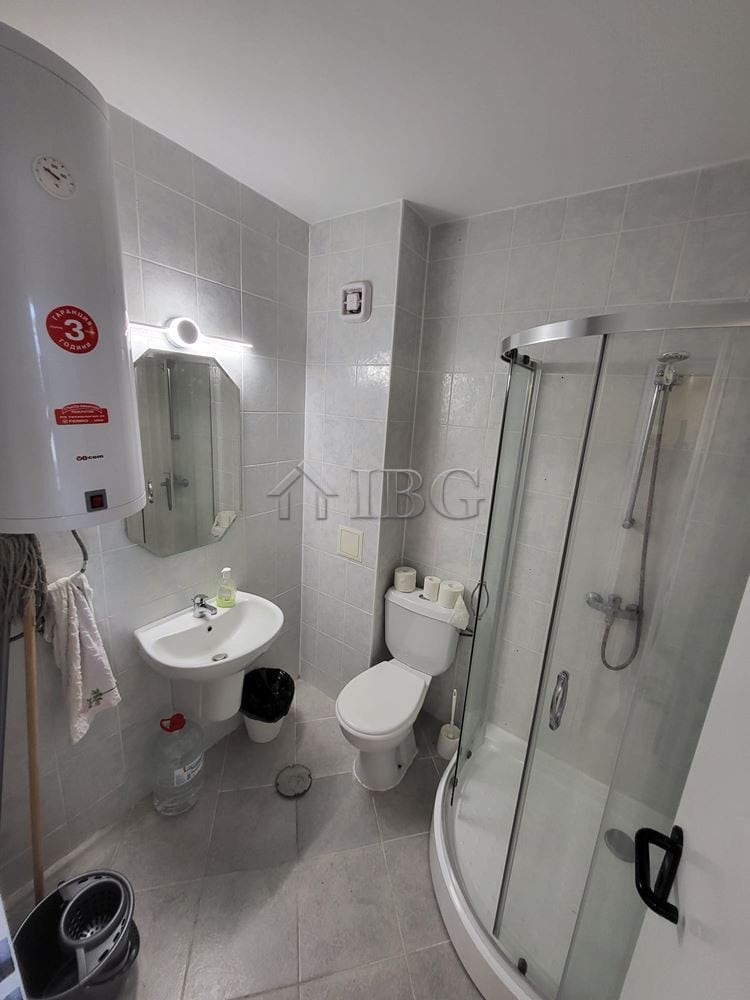 Compact bathroom with shower, toilet, and sink in Sunset Kosharitsa.