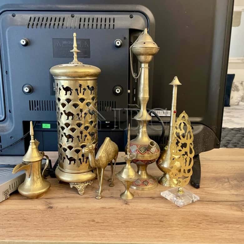 Brass decorative ornaments displayed on a wooden desk in a contemporary apartment setting.
