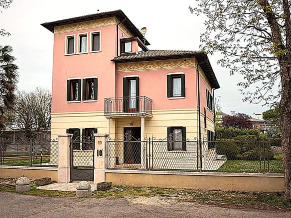 Elegant pink villa with modern design and spacious garden.