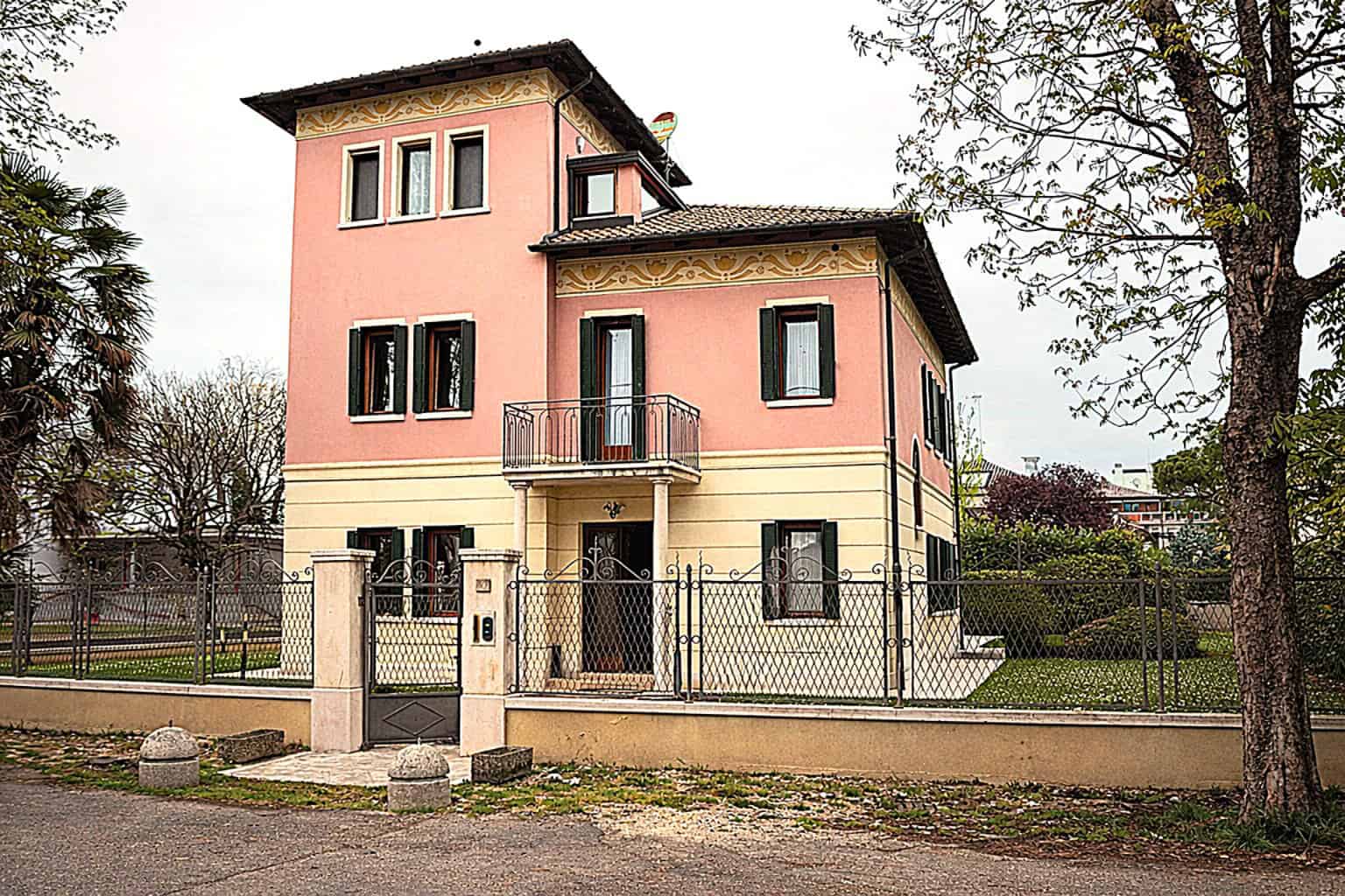 Elegant pink villa with modern design and spacious garden.