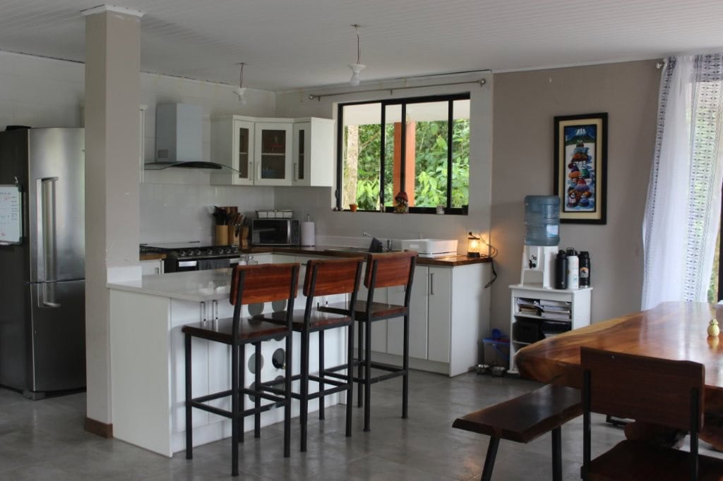 Bright kitchen with white cabinets, stainless steel appliances, and large window.