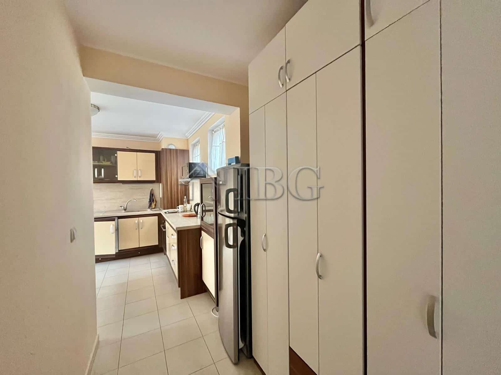 Modern kitchen with white cabinets, refrigerator, and natural light in Laguna 3, Sunny Beach.