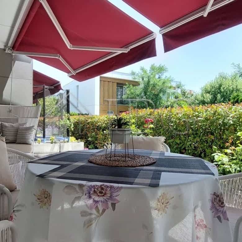Elegant outdoor terrace of a luxury two-storey townhouse featuring a garden view and comfortable sea.