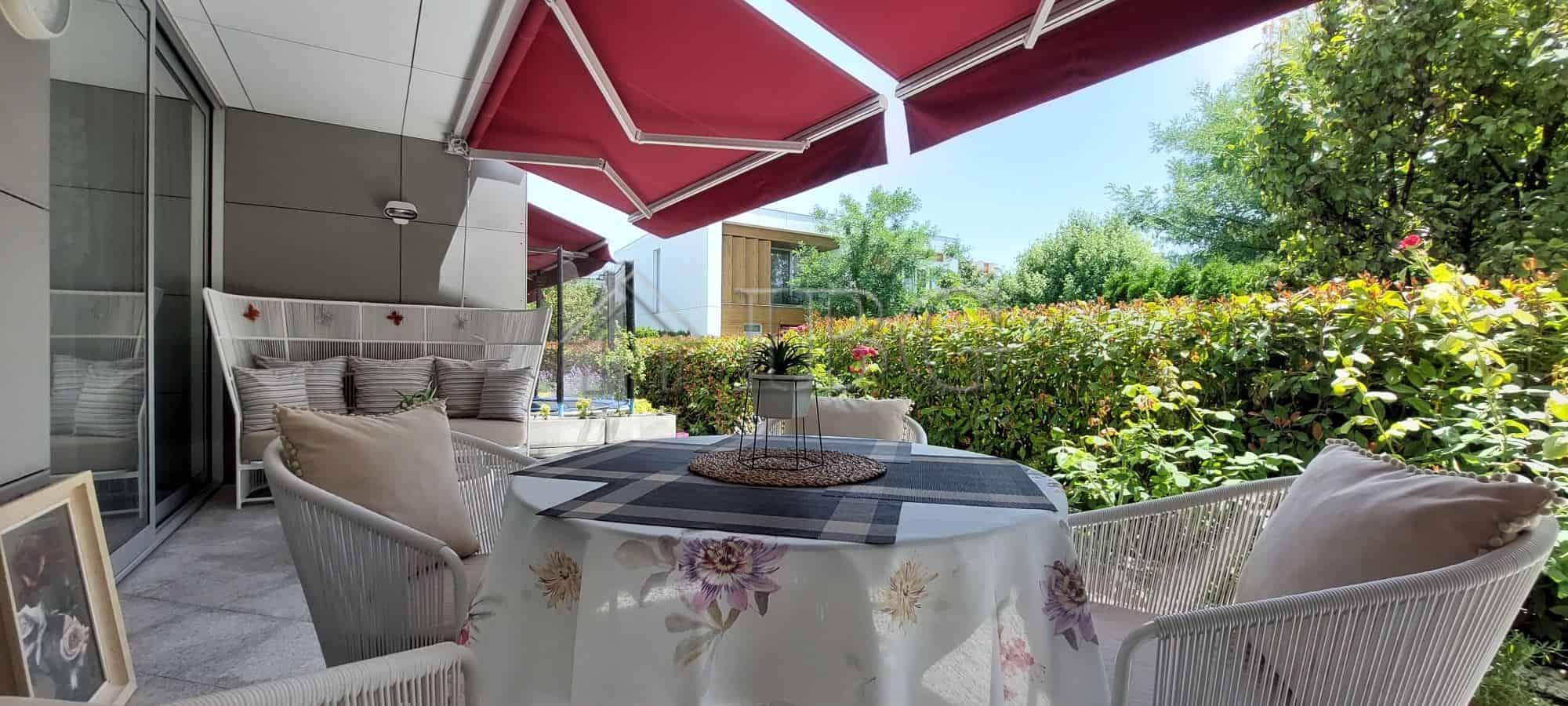 Elegant outdoor terrace of a luxury two-storey townhouse featuring a garden view and comfortable sea.