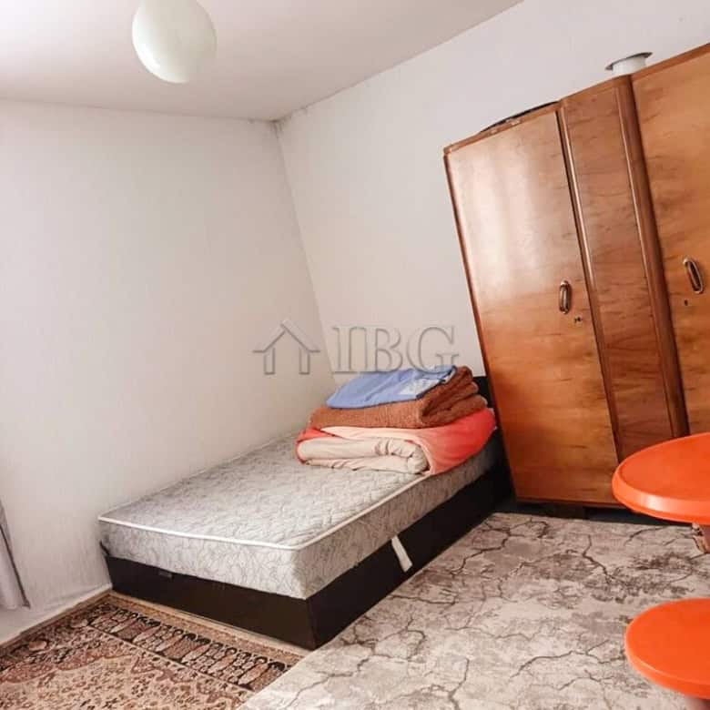 Bright interior of a well-maintained two-storey house with a bedroom, wardrobe, and garden access.