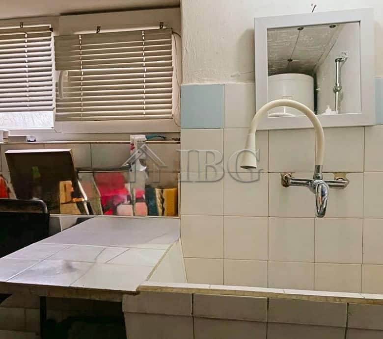 Interior laundry area with sink, window, and storage space in a well-maintained home.