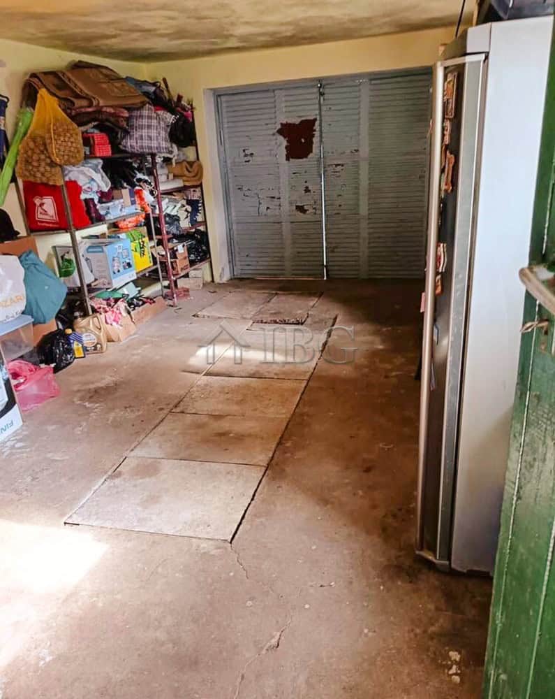 Garage with storage space and metal sliding door in a well-maintained house.