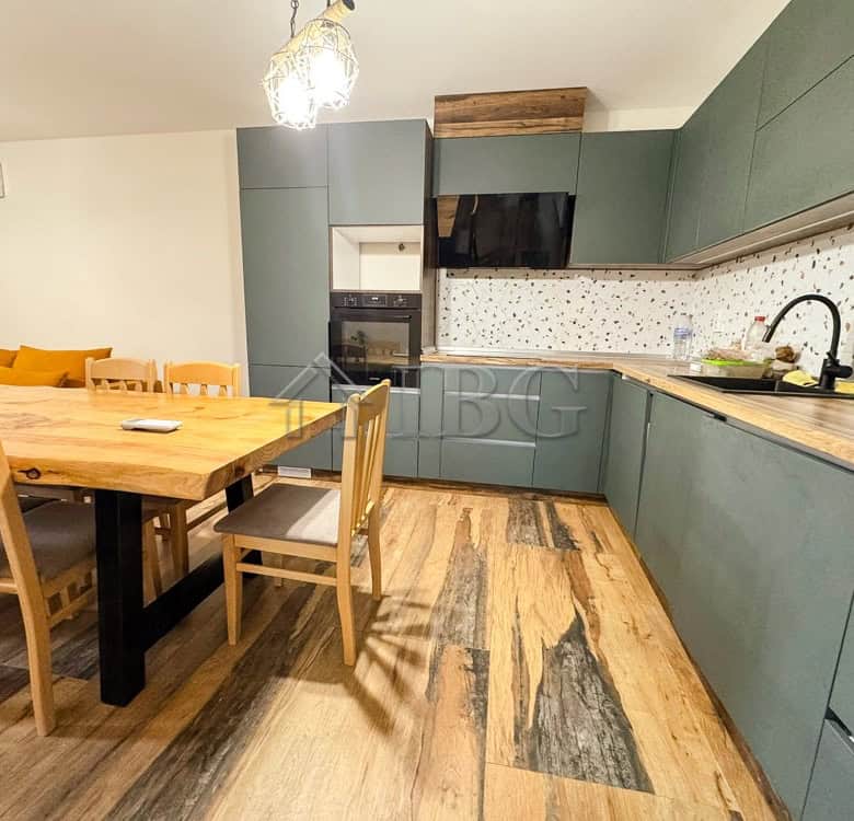 Modern family apartment kitchen with green cabinets and wooden accents in Ruse, Bulgaria.