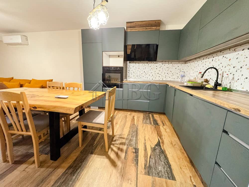 Modern family apartment kitchen with green cabinets and wooden accents in Ruse, Bulgaria.