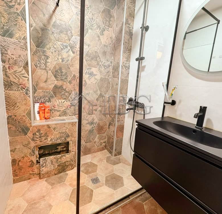 Stylish bathroom featuring a walk-in shower, hexagonal tiles, and contemporary fixtures in a luxury.