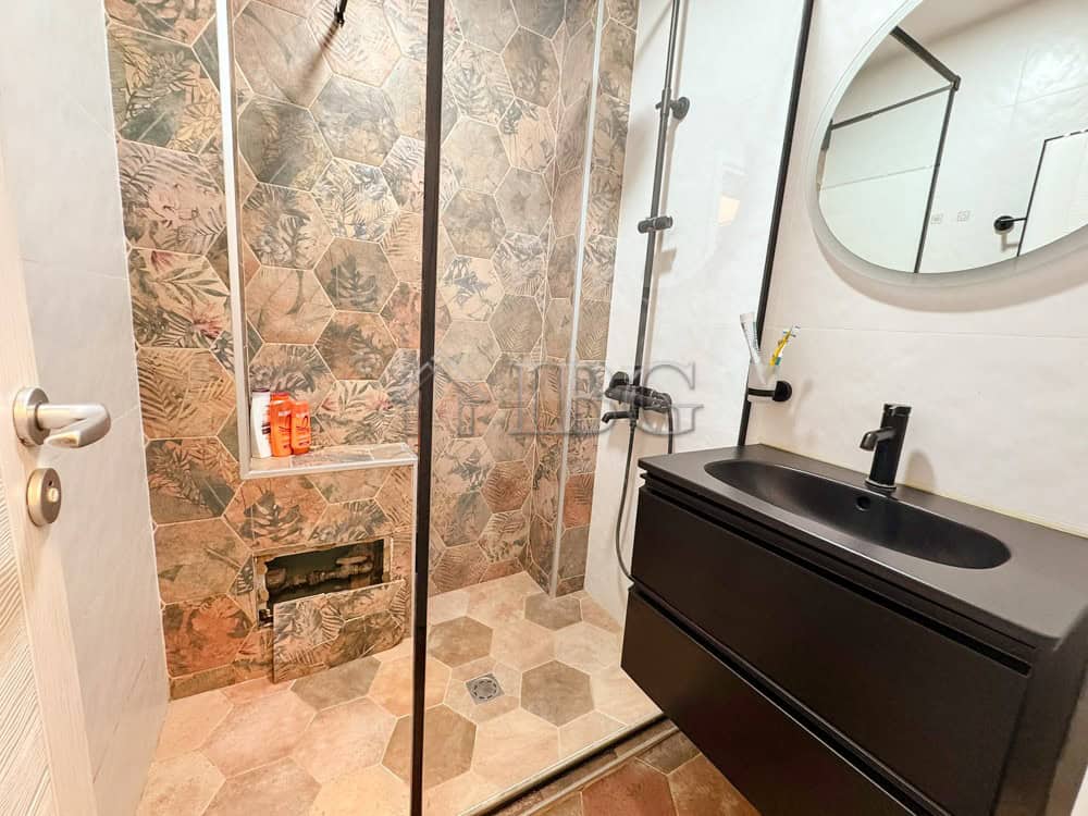 Stylish bathroom featuring a walk-in shower, hexagonal tiles, and contemporary fixtures in a luxury.