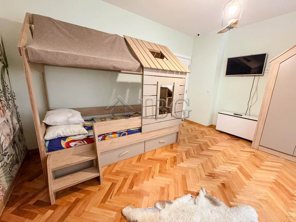 Bright children's room featuring a house-shaped bed with storage drawers and a playful design.