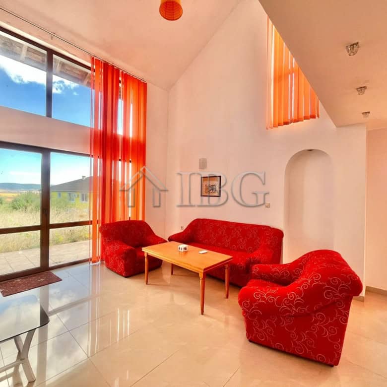 Cozy living room with large windows and vibrant orange curtains in Aleksandrovo, Burgas.