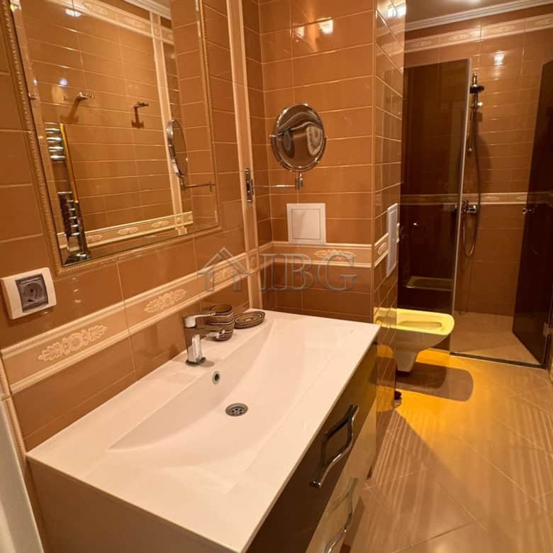 Bathroom with beige tiles, modern sink, and mirror in Villa Florence, Sveti Vlas.