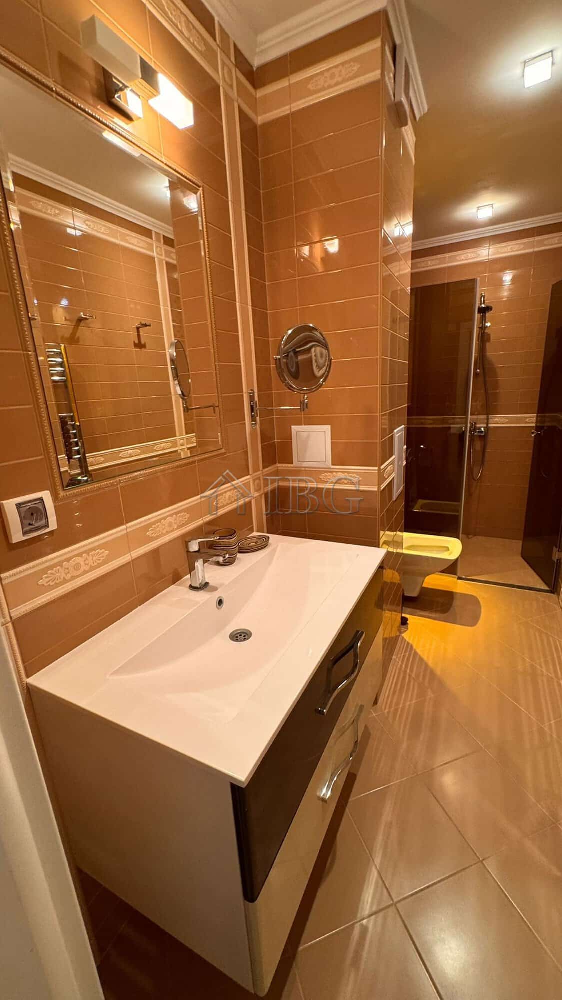 Bathroom with beige tiles, modern sink, and mirror in Villa Florence, Sveti Vlas.