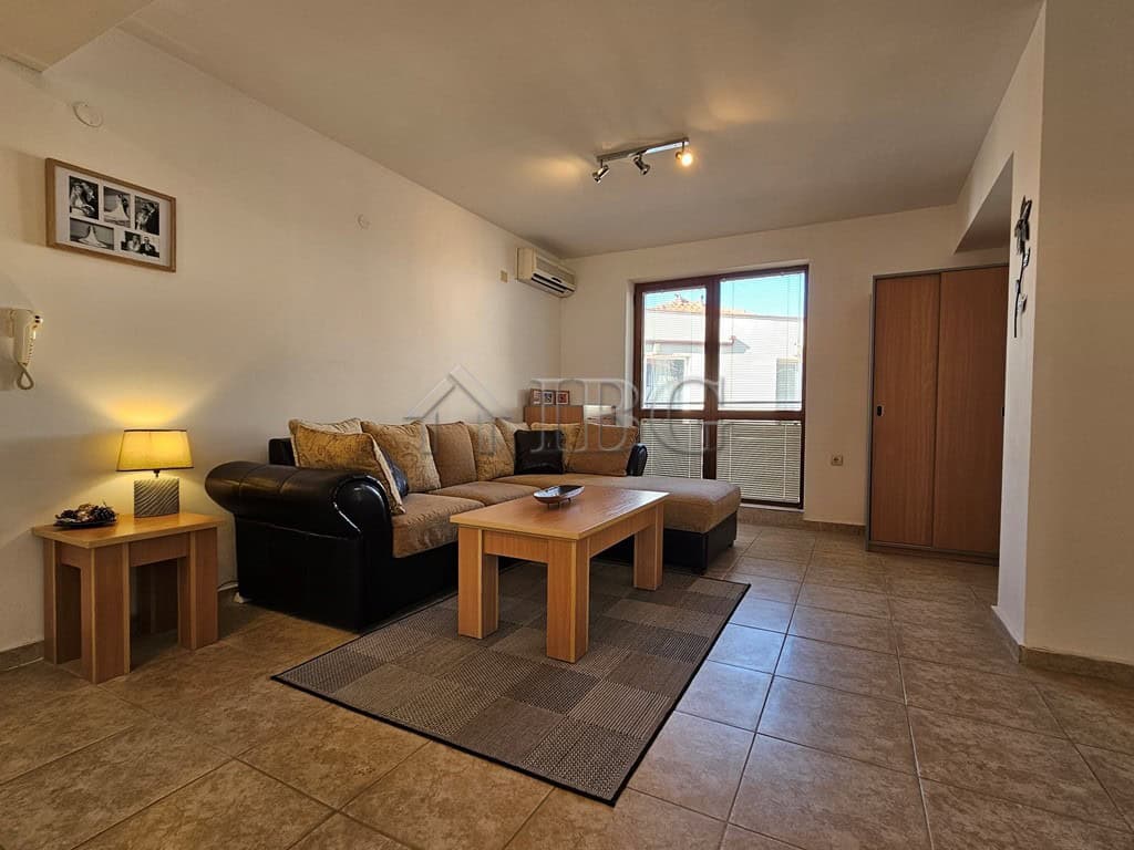 Bright living room with sofa, coffee table, and large window in Sveti Vlas apartment.