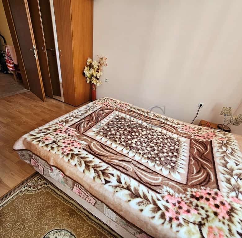 Sea view bedroom with cozy decor and large window.