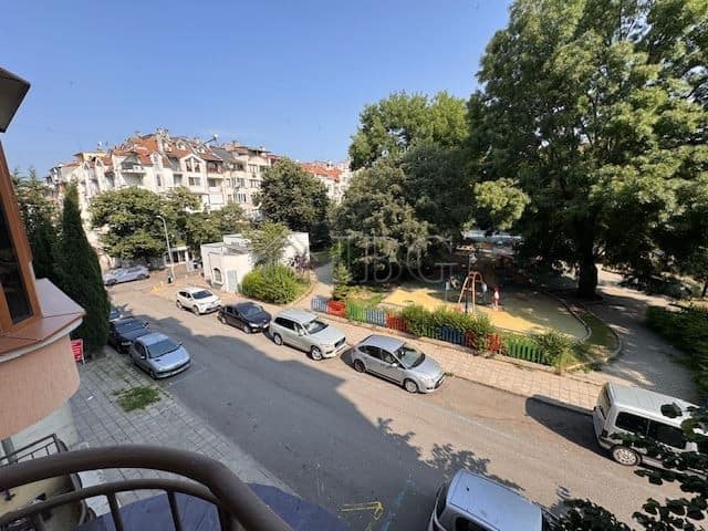 Bright view of Vazrazhdane neighborhood with parked cars and green park nearby.