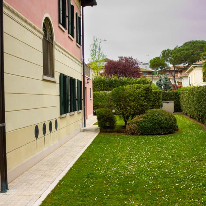 Beautiful garden with trimmed bushes and vibrant grass in a peaceful neighborhood.
