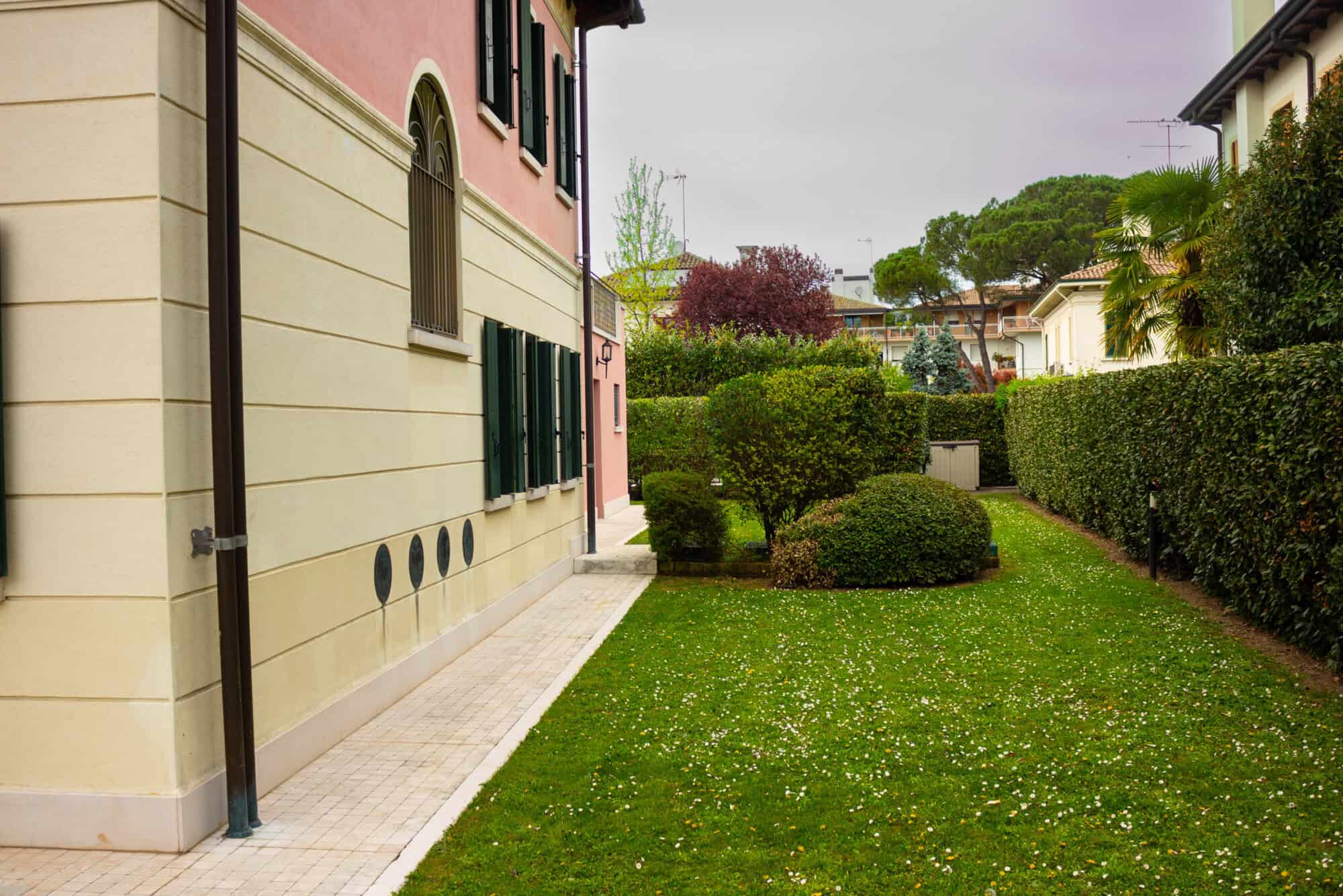 Beautiful garden with trimmed bushes and vibrant grass in a peaceful neighborhood.