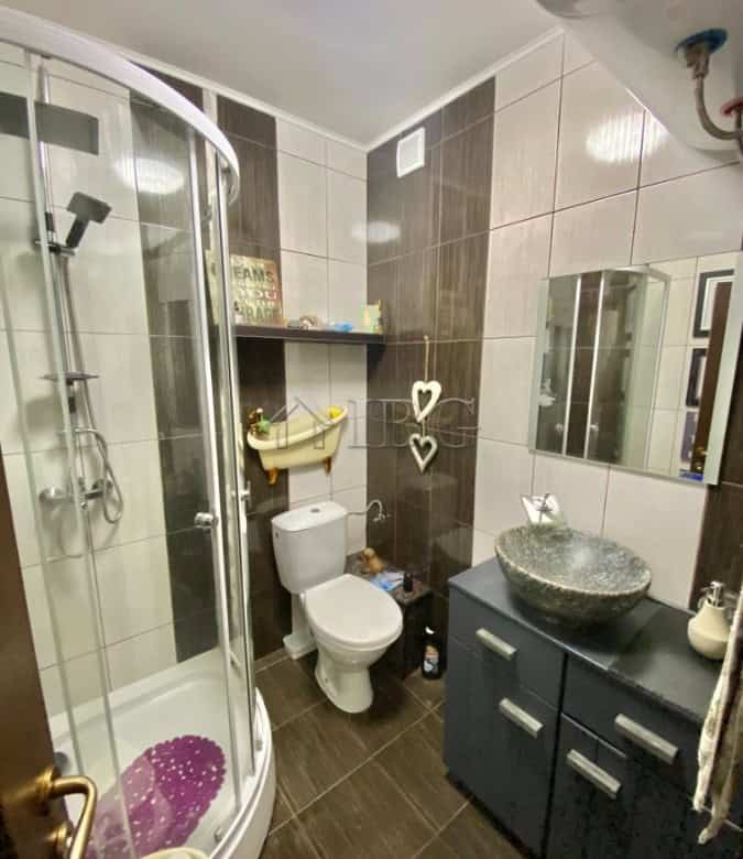 Bright bathroom with modern fixtures and a stylish stone sink.