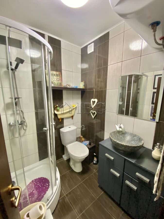 Bright bathroom with modern fixtures and a stylish stone sink.