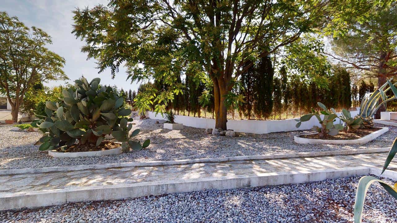 Charming boutique hotel for sale in Caniles, Granada, featuring lush gardens and outdoor seating are.