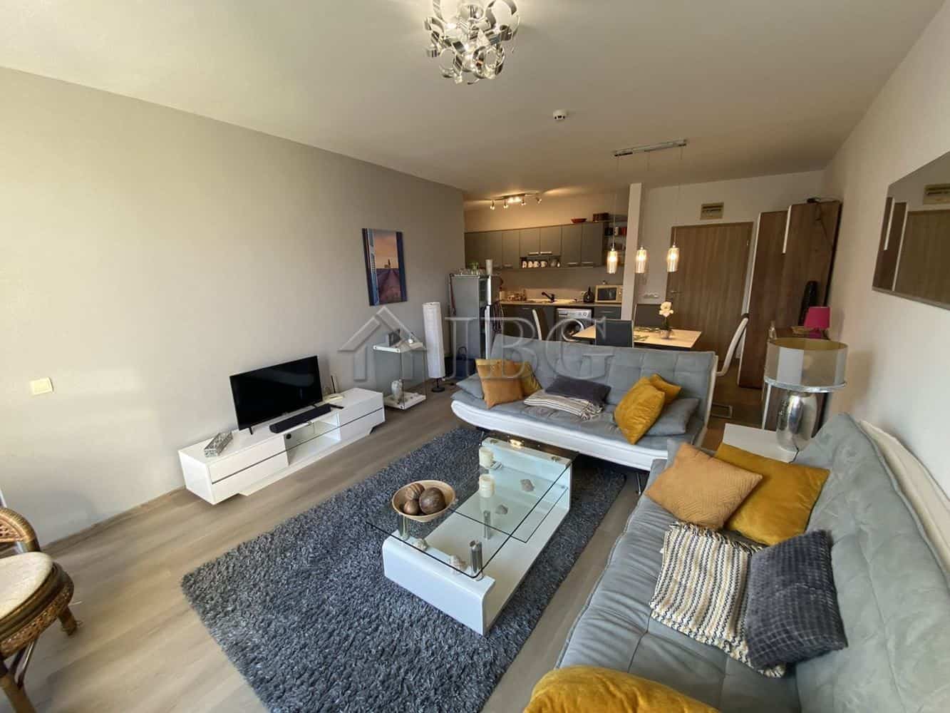 Spacious living room with contemporary furniture, TV, and cozy cushions in Vineyards Resort, Aheloy.
