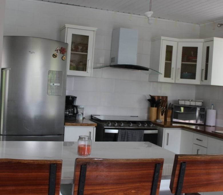Spacious kitchen with white cabinets, stainless steel appliances, and a breakfast bar in a beautiful.