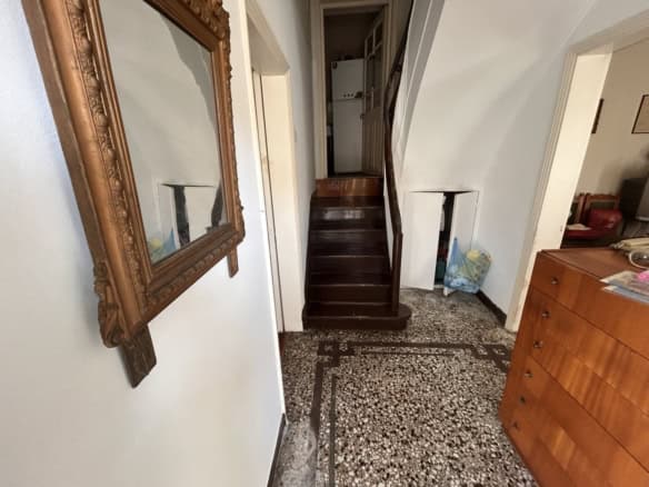 Interior view of a cozy home featuring dark wooden stairs and classic decor.