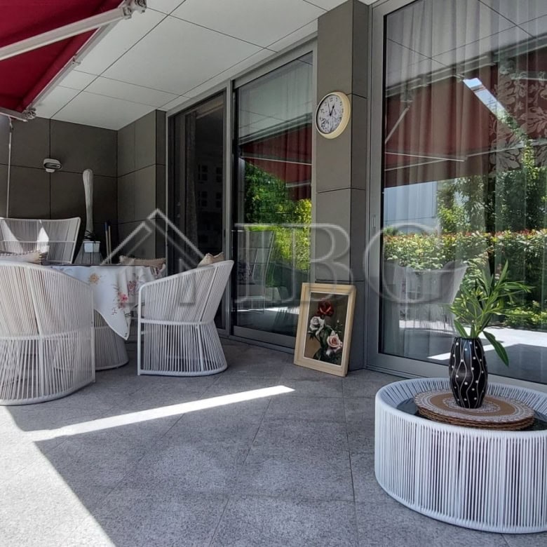 Modern townhouse terrace with outdoor seating and garden views.