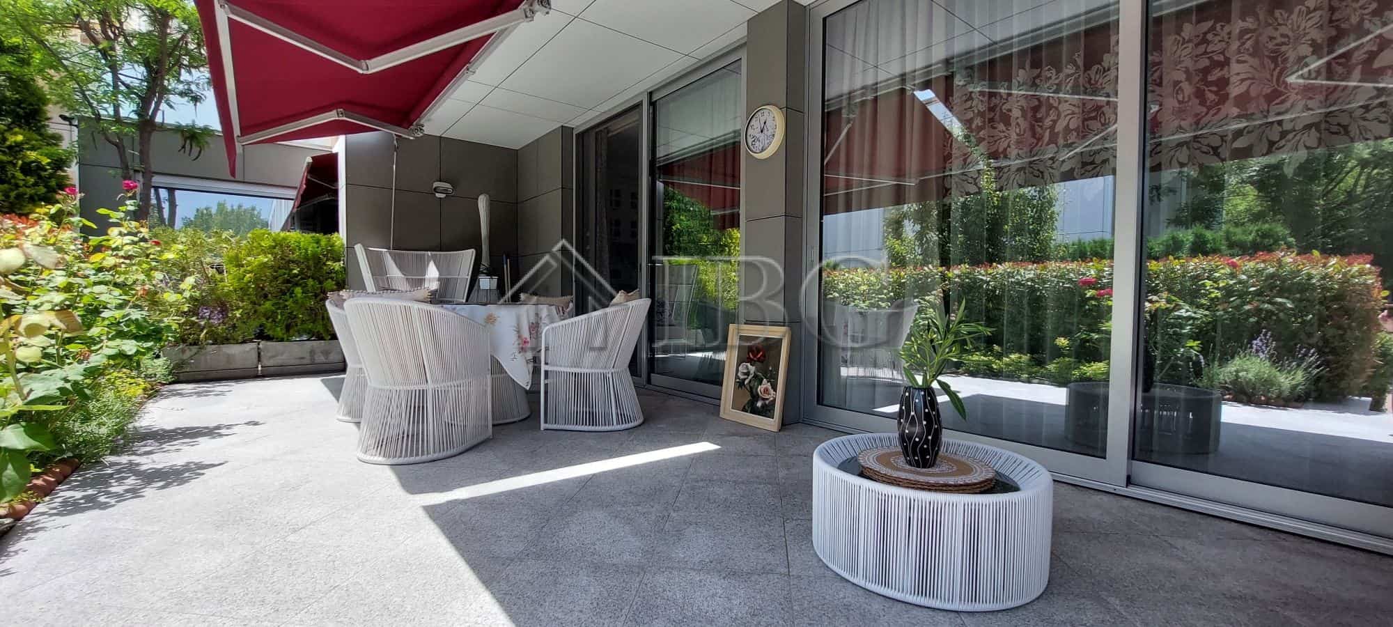 Modern townhouse terrace with outdoor seating and garden views.