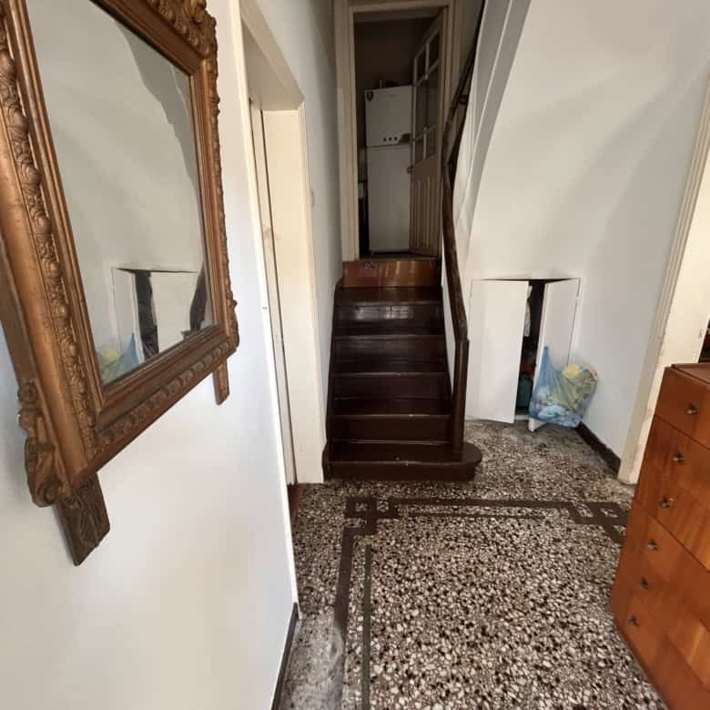 Interior view of a cozy home featuring dark wooden stairs and classic decor.