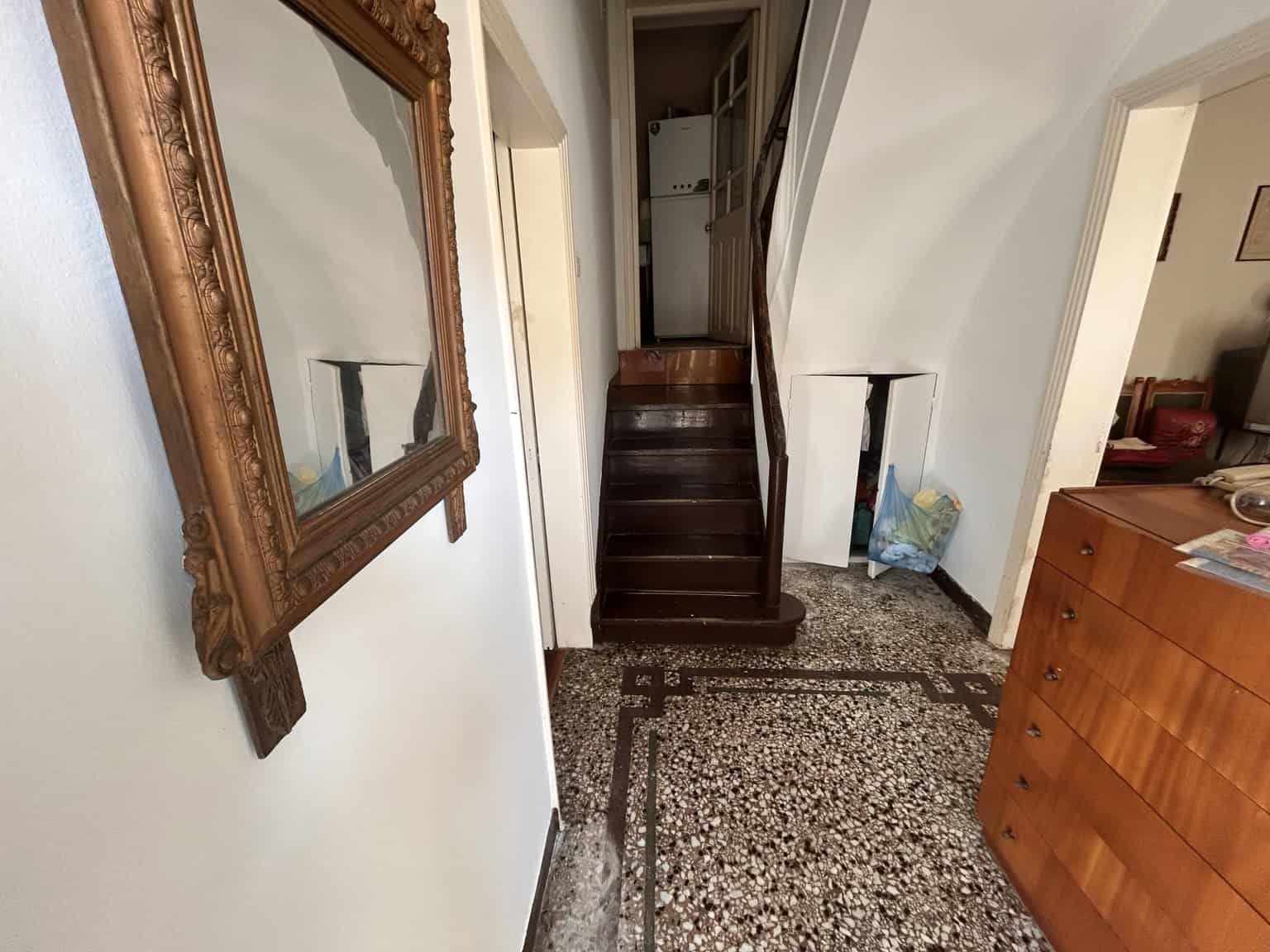 Interior view of a cozy home featuring dark wooden stairs and classic decor.