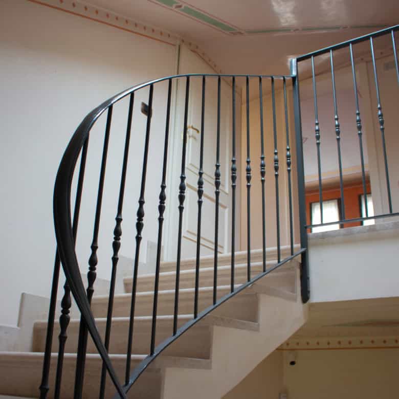Elegant staircase with black metal railing in a contemporary home interior.